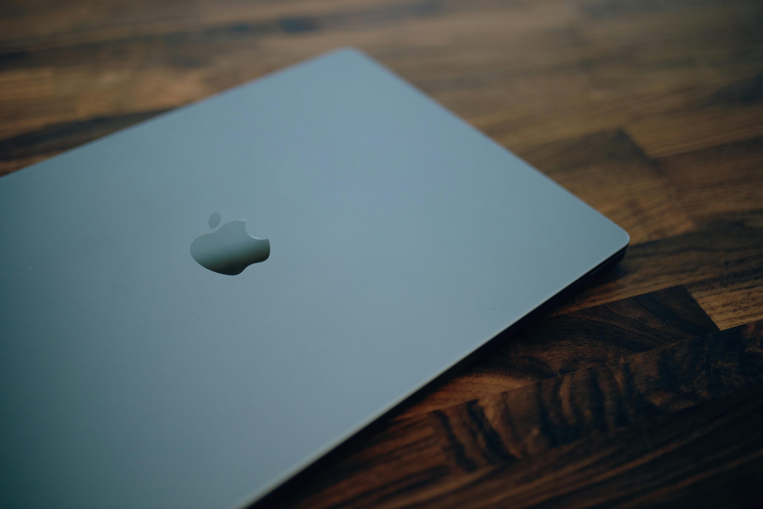 Close-up of a sleek modern laptop with minimalistic design on a wooden table surface.