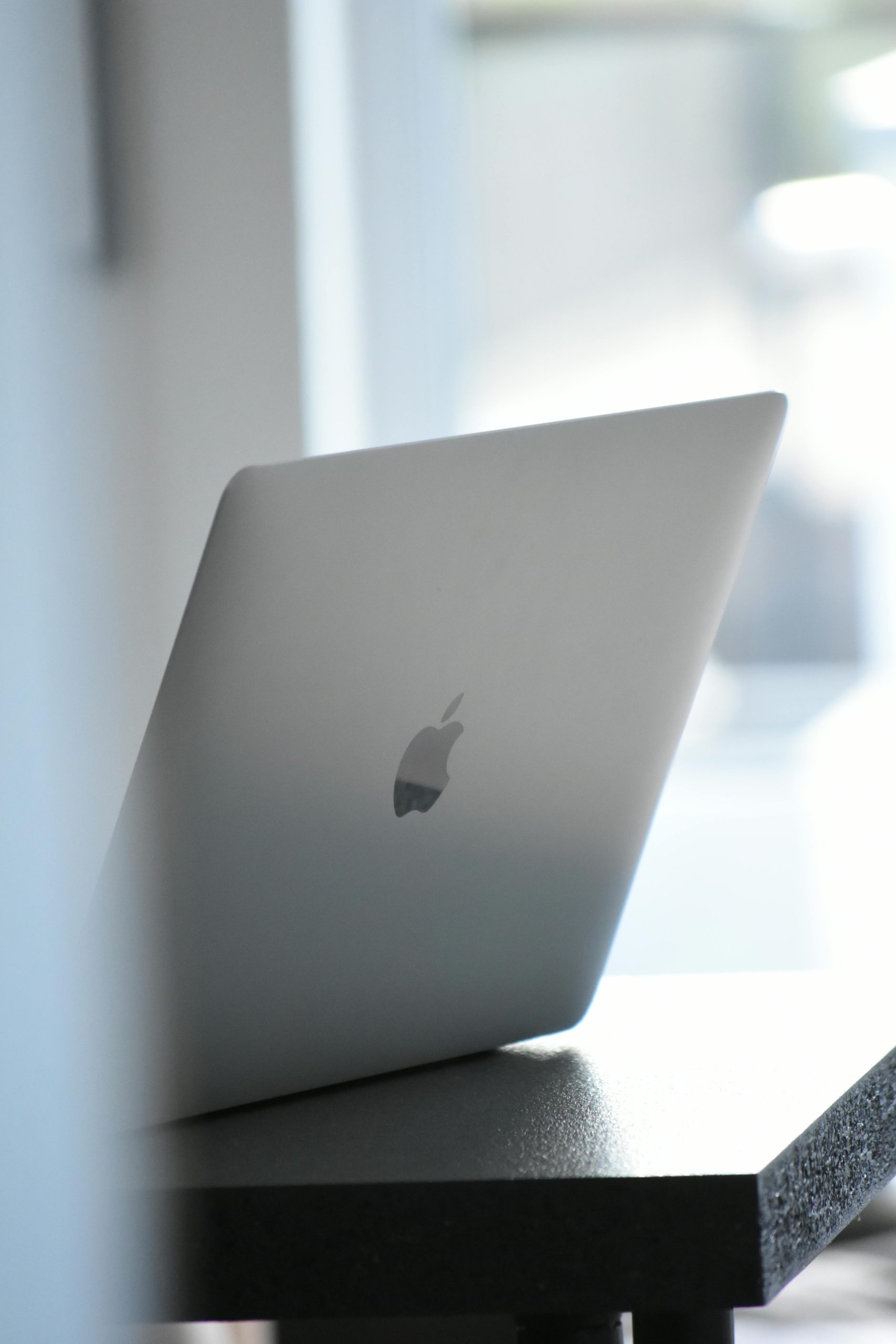 Elegant silver laptop placed on a modern desk indoors, ideal for tech and workspace themes.