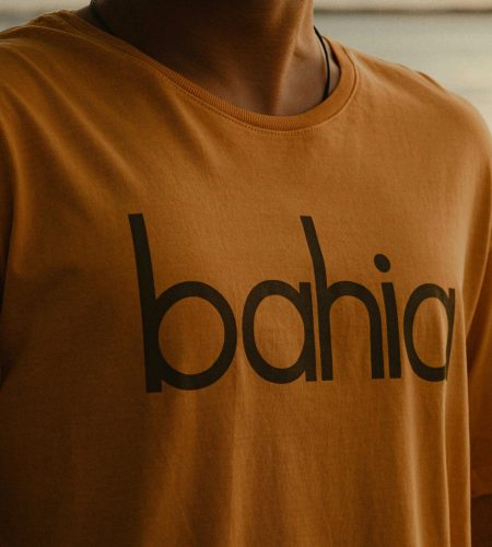 Close-up of a man wearing a Bahia-themed t-shirt outdoors during sunset.